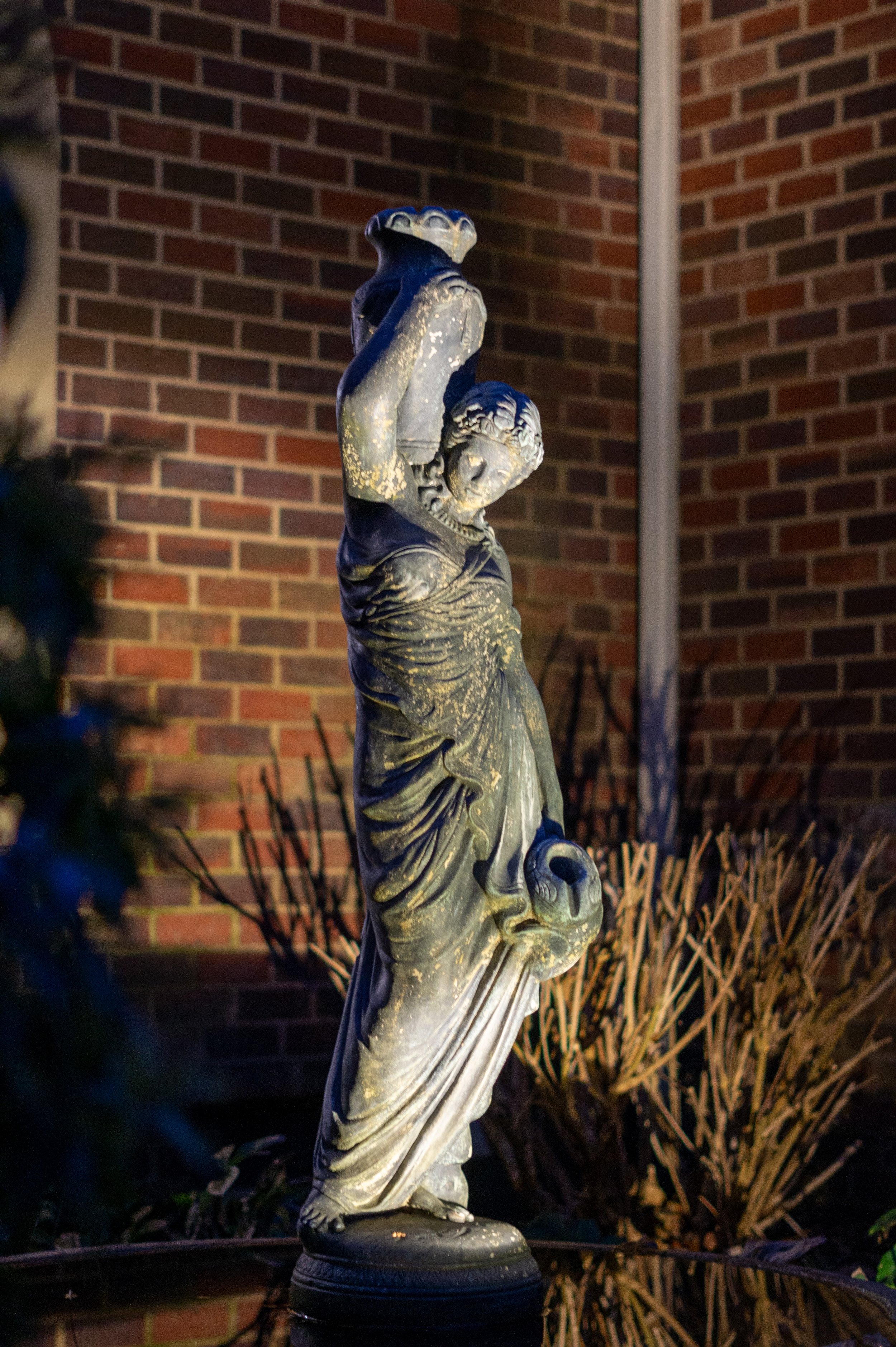 Statue of Rebekah at the well is illuminated with exterior accent lights.