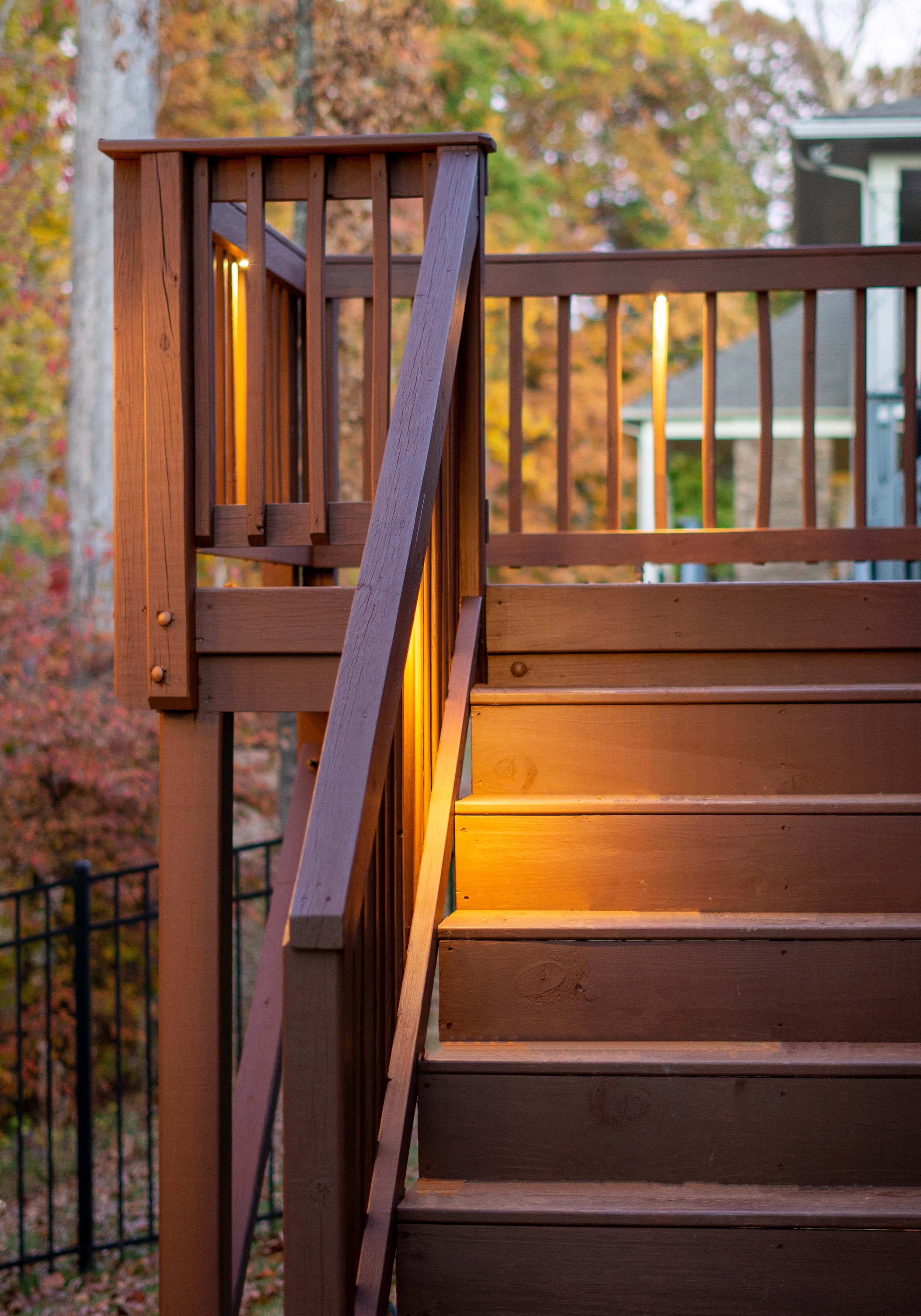 Brown deck and stairs illuminated with professional deck lighting.